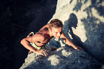 Men climbs a rock and smiles