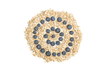 Heap of oat flakes in circle shape. Tropical abstract background with rolled oats. Berries on the white background.