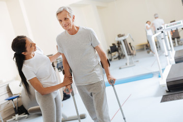 Smiling senior man leaning on walking sticks