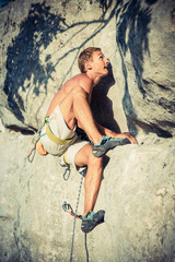 Men climbs a rock and makes hard move, bouldering