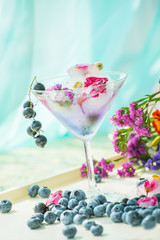 Wet a glass in drops with a cold drink. Berries of currants and blueberries. Lovely summer atmospheric background.
