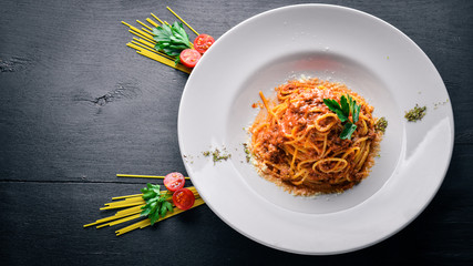Pasta with tomato sauce and parmesan cheese. Italian traditional food. On a wooden background. Top view. Free space for your text.
