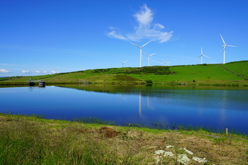 Landscape view of giant wind turbines on a hill overlooking a river in Scotland