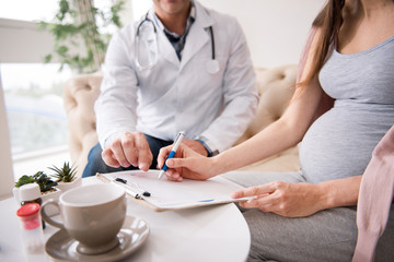 Worried young mommy signing documents