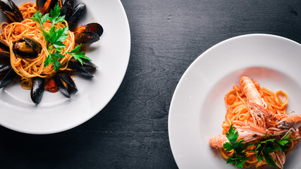 Pasta with mussels and seafood. Italian traditional food. On a wooden background. Top view. Free space for your text.