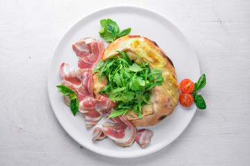 Salad with meat and vegetables. Italian cuisine. On a wooden background. Top view. Free space for your text.