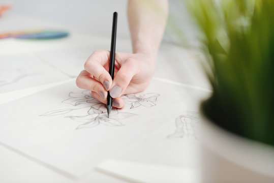 Young female illustrator working on sketches at home office