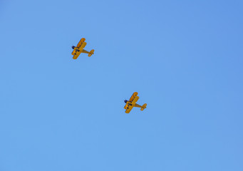 two vintage airplane in flight . at empty blue sky