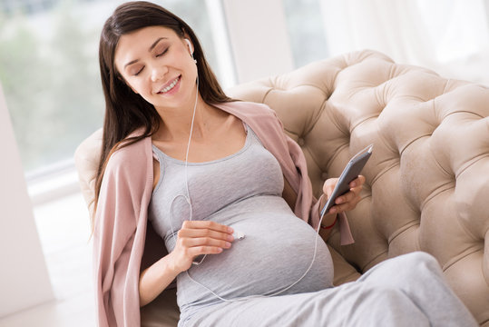 Joyful pregnancy relaxing while listening music
