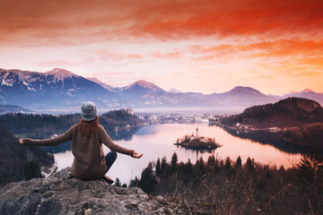 Fototapeta na wymiar Traveling young woman looking on sunset on Bled Lake, Slovenia, Europe