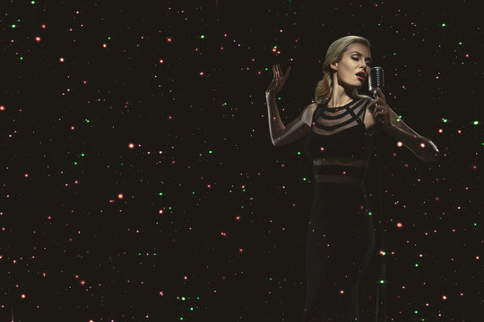 The singer is on stage with a microphone.