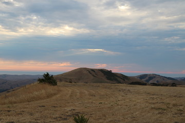 Sunset over the Pacific Ocean under cloudy skies and rain