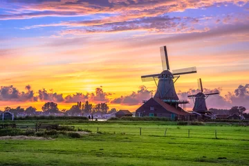 Fotobehang Traditional village with dutch windmills and river at sunset, Holland, Netherlands. © gatsi