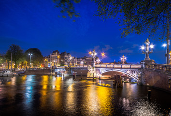 Fototapeta premium Amsterdam at night, with flowers and bicycles on the bridge, Holland, Netherlands.