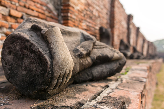 Detail of many headless Buddhas along a temple wall at Wat Mahathat, Temple of the Great Relic, in Ayutthaya, Thailand