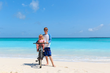 Obraz na płótnie Canvas father with little daughter biking at beach