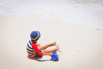 Fototapeta na wymiar little boy play with sand on beach