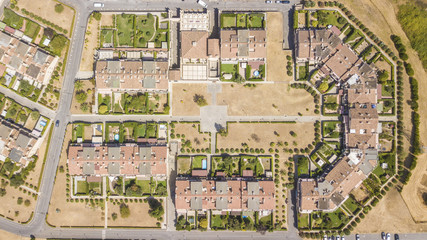 Fototapeta na wymiar Vista aerea ortogonale di un quartiere periferico della città di Roma. Le costruzioni sono ville moderne e anche l'urbanistica è futuristica. Tanti sono gli alberi piantati intorno alle abitazioni.