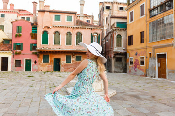 Woman tourist travel in Italy. Young girl with a white hat in venice on an old street. Girl traveling to Venice.