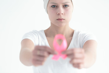 Woman with tumor holding ribbon