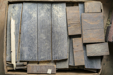 Cardboard box of old cut offs of wood planking in different sizes viewed from above in a DIY or renovations concept