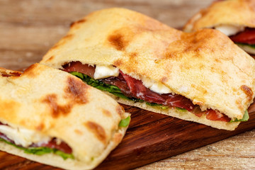 Sliced pizza calzone whith ham on wooden board