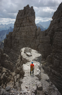 Rock climber standing on top of the rock in Dolomites
