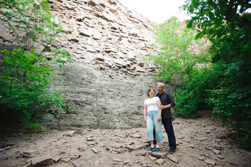 Active loving senior couple walking in beautiful summer forest - active retirement concept