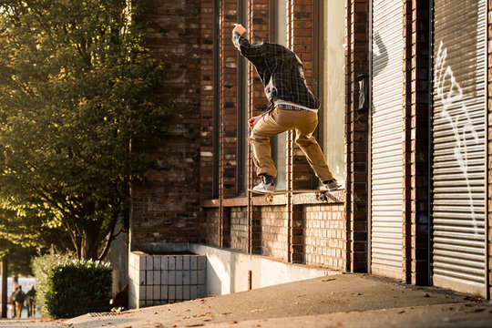 Skateboarder tricks at street