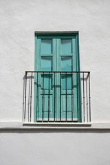 turquoise balcony door in whitewashed wall