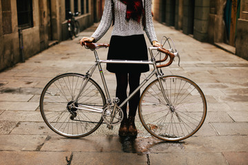 Closeup of a woman with her vintage bicycle on the street.