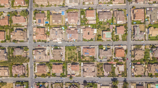 Vista aerea ortogonale di una parte del quartiere Marco Simone nella periferia nord a Roma. Tra le strade strette, le ville e i palazzi si vedono alberi. Sugli edifici ci sono antenne e parabole.