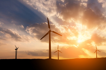 Wind turbines on the sunset sky background