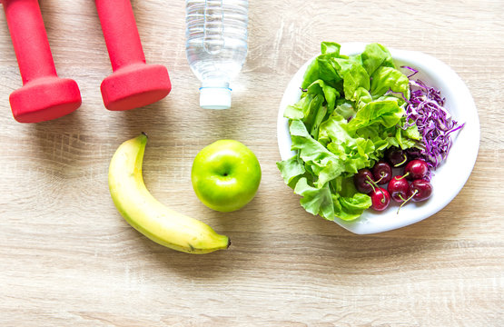 Healthy lifestyle for women diet with sport equipment, sneakers, measuring tape, fruit healthy green apples and bottle of water on wooden.  Healthy Concept.