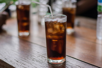 Soft drink with ice in the glass on a table.