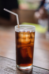 Soft drink with ice in the glass on a table.