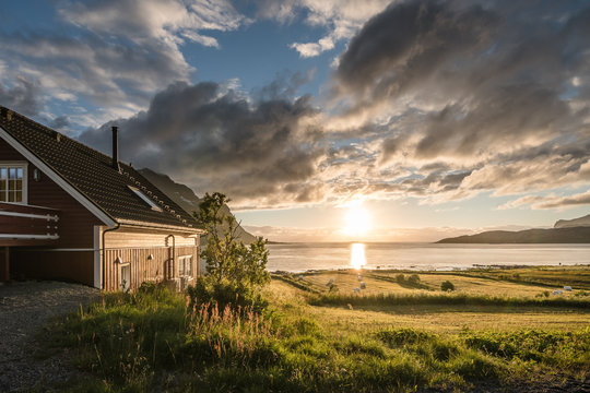 Rotes Haus in der Mittsommernacht am Nappstraumen, Lofoten, Norwegen