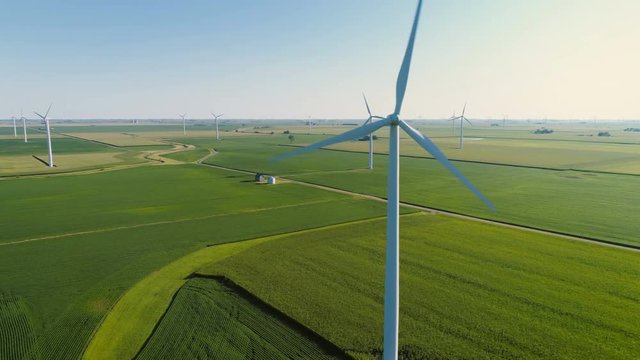 Aerial Close Up shot of Wind Turbine on countryside green field
