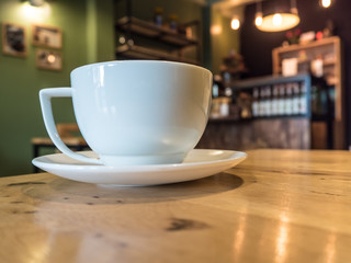 Close up front white coffee cup on wood desk in cafe coffee shop