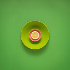 Dinner is served / Creative concept photo of kitchenware, painted plate with food on it on green background.