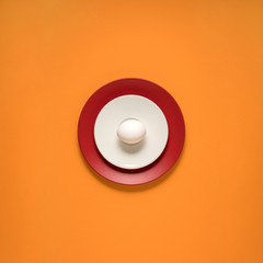 Dinner is served / Creative concept photo of kitchenware, painted plate with food on it on orange background.