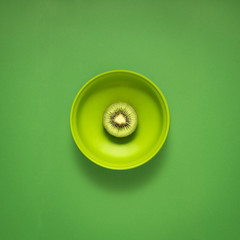 Dinner is served / Creative concept photo of kitchenware, painted plate with food on it on green background.