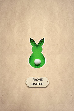 Frone Ostern / Creative easter concept photo of a rabbit made of paper on brown background. Frone Ostern.