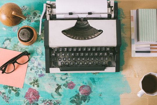Overhead view of typewriter and various items on the floral vintage table