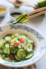 Cucumber salad in Chinese chopsticks, Asian cuisine, spices
