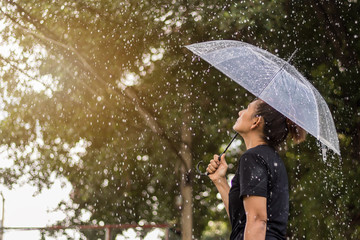Asian woman under an umbrella in the rain. - 166723057