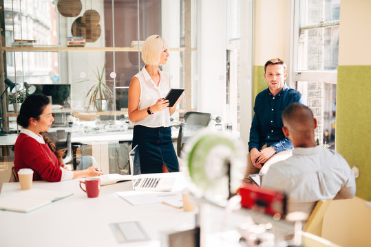 Business meeting at work at trendy startup company presenting pitch for growth and development