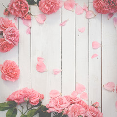 Romantic pink roses on white wooden background