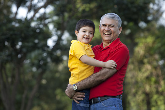 Portrait of grandfather and grandson in a park