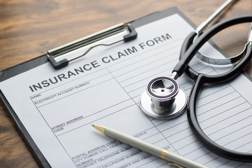 health insurance claim form with stethoscope on wood table selective focus